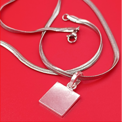 Silver necklace with a square pendant on a red background
