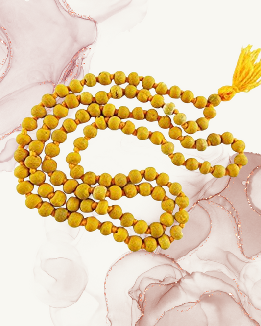 Yellow beaded necklace with a tassel on a pink floral background
