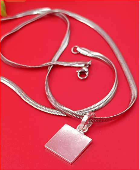 Silver necklace with a square pendant on a red background