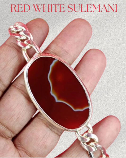 Red and white stone pendant held in a hand with 'Red White Sulemani' text above.